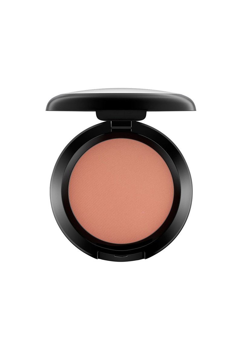 Compact de blush rond avec une finition noire mate. L'intérieur révèle une poudre douce de teinte pêche avec une texture de surface nervurée. Le couvercle est partiellement ouvert.
