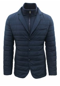 Blazer trapuntato blu navy con colletto alto, chiusura frontale con zip e tre bottoni. Presenta una tasca sul petto e due tasche laterali. Tessuto testurizzato.