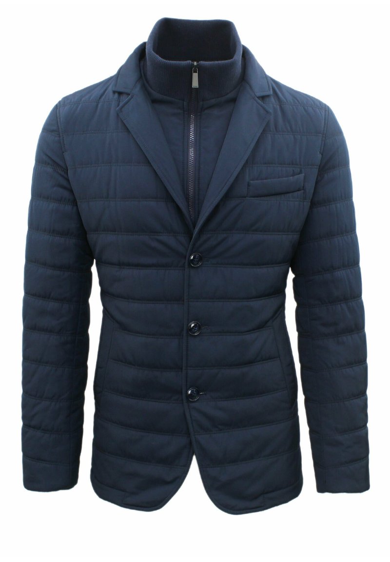 Blazer trapuntato blu navy con colletto alto, chiusura frontale con zip e tre bottoni. Presenta una tasca sul petto e due tasche laterali. Tessuto testurizzato.