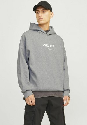 Grey sweatshirt with a hood, featuring a front logo print. Stitched cuffs and hem, paired with black cargo pants.