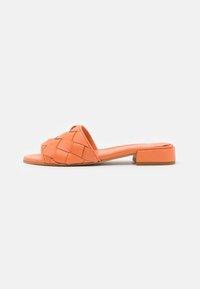 Orange woven leather slip-on sandal with a flat heel and open toe. Features a textured upper and a smooth footbed. Simple design.