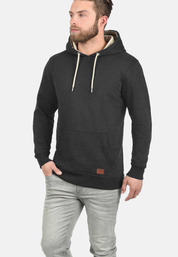 Sudadera negra de mezcla de algodón, con un bolsillo tipo canguro, cordones, puños acanalados y un pequeño parche de cuero en el dobladillo.