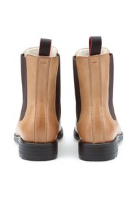 Brązowe skórzane botki za kostkę z elastycznymi panelami bocznymi. Okrągły nos, detal w kontrastowym kolorze oraz pętla na tyle. Czarna gumowa podeszwa.