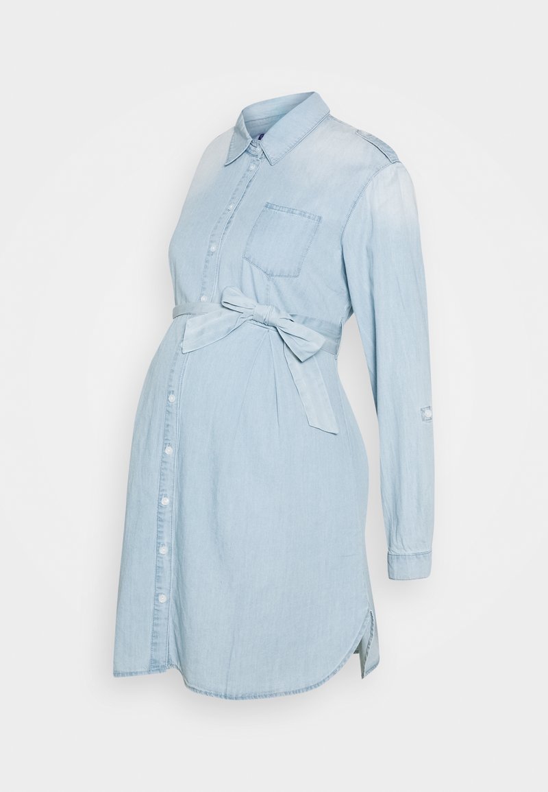 Ljust blå denim gravidklänning med krage, knapplist framtill, bröstficka och justerbart bälte i midjan. Långa ärmar.