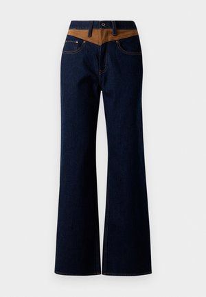 Dark blue denim flared jeans with a contrasting tan waistband, featuring two front pockets and subtle stitching details.
