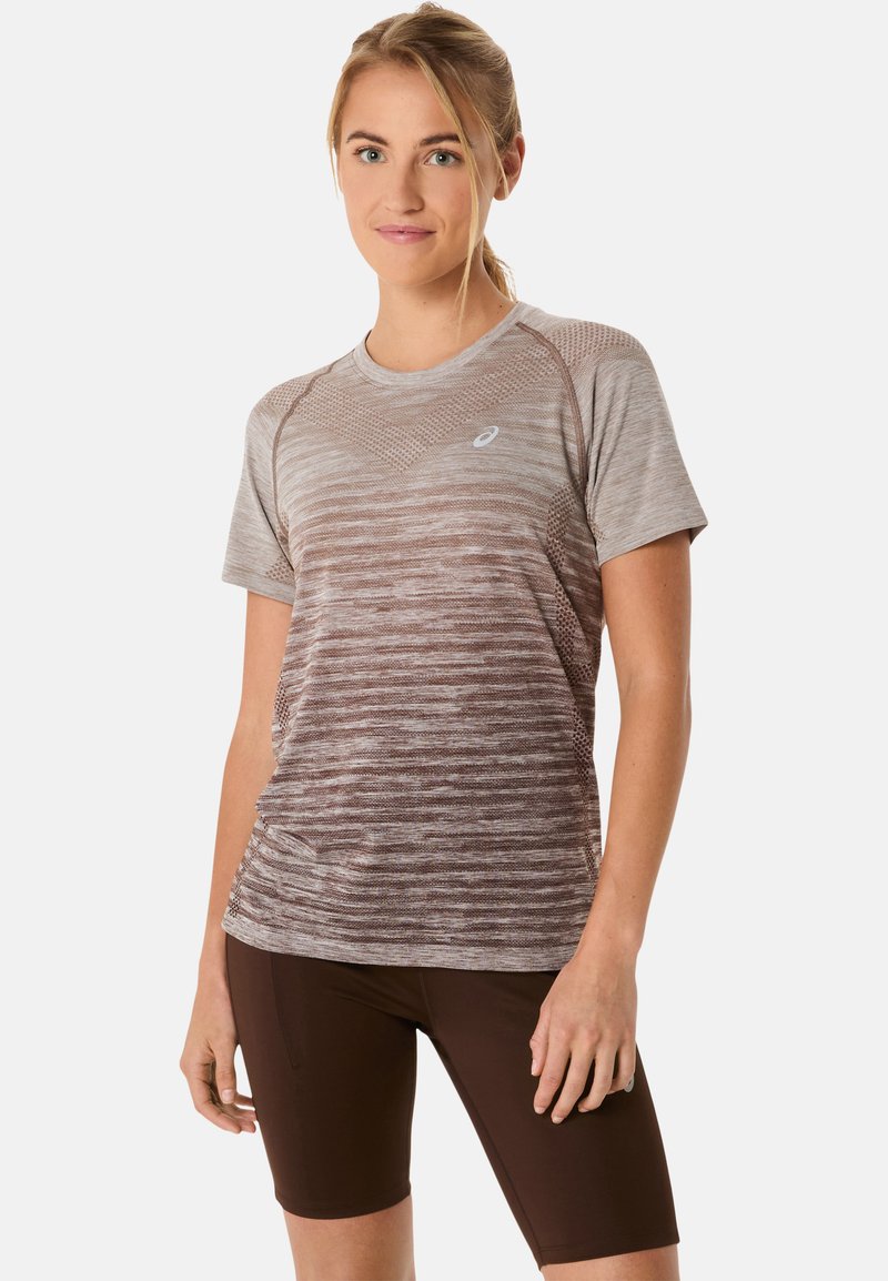 Brązowa, gradientowa koszulka sportowa z krótkim rękawem, z fakturowanym wzorem i logo na piersi, w zestawie z ciemnobrązowymi szortami kolarskimi.