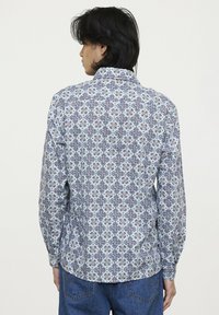 Langarmhemd in Hellblau mit komplexem Paisleymuster in Dunkelblau und Kastanienbraun. Mit Button-down-Kragen und abgerundetem Saum.