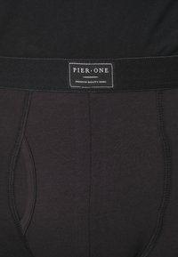 Black cotton underwear featuring a soft elastic waistband with a label reading "PIER-ONE" and "PREMIUM QUALITY GOODS."