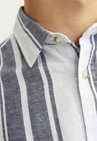 Camicia a righe con bottoni, caratterizzata da righe verticali blu e bianche, colletto classico e dettagli con bottoni, realizzata in tessuto leggero.