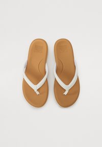 White flip-flops with a soft textured sole, featuring a smooth leather strap and rubber toe post, on a plain white background.