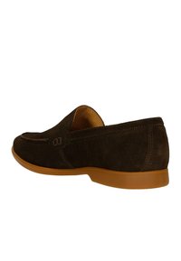 Scarpa slip-on in suede marrone scuro con punta arrotondata, suola in cuoio chiaro che contrasta e dettagli di cucitura discreti lungo i bordi.