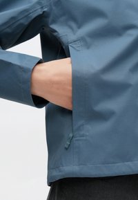 Μπλε ελαφρύ μπουφάν με λεία υφή, διαθέτει πλαϊνή τσέπη και άνετη εφαρμογή. Το τελε ίωμα στο κάτω μέρος έχει καθαρό ράψιμο.