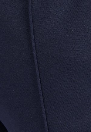 Navyblauwe stof close-up, met een gestructureerd breipatroon en zichtbare naaddetails, die een gladde, gelijkmatige oppervlakte toont.