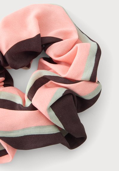 Μαλακό ύφασμα scrunchie με φαρδιές οριζόντιες ρίγες σε ροζ, σκούρο καφέ και ανοιχτό γκρι, τοποθετημένο σε χαλαρό βρόχο σε λευκό φόντο.