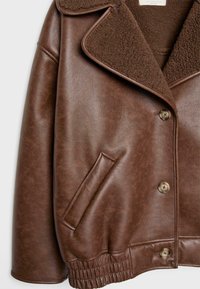 Giacca in finta pelle marrone con colletto in shearling, chiusura a bottone, tasca frontale angolata e dettaglio in vita elasticizzato.