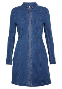 Sukienka dżinsowa z kołnierzykiem, długimi rękawami i zamkiem błyskawicznym z przodu. Posiada dwie kieszenie na piersiach oraz dopasowany krój, z wyraźnymi przeszyciami.