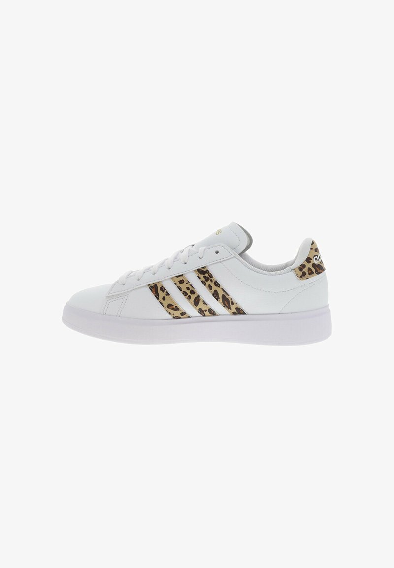 Białe sportowe sneakersy z akcentami w leopardzi wzór i trzema poziomymi paskami po boku. Wykonane z materiałów syntetycznych, z gumową podeszwą.