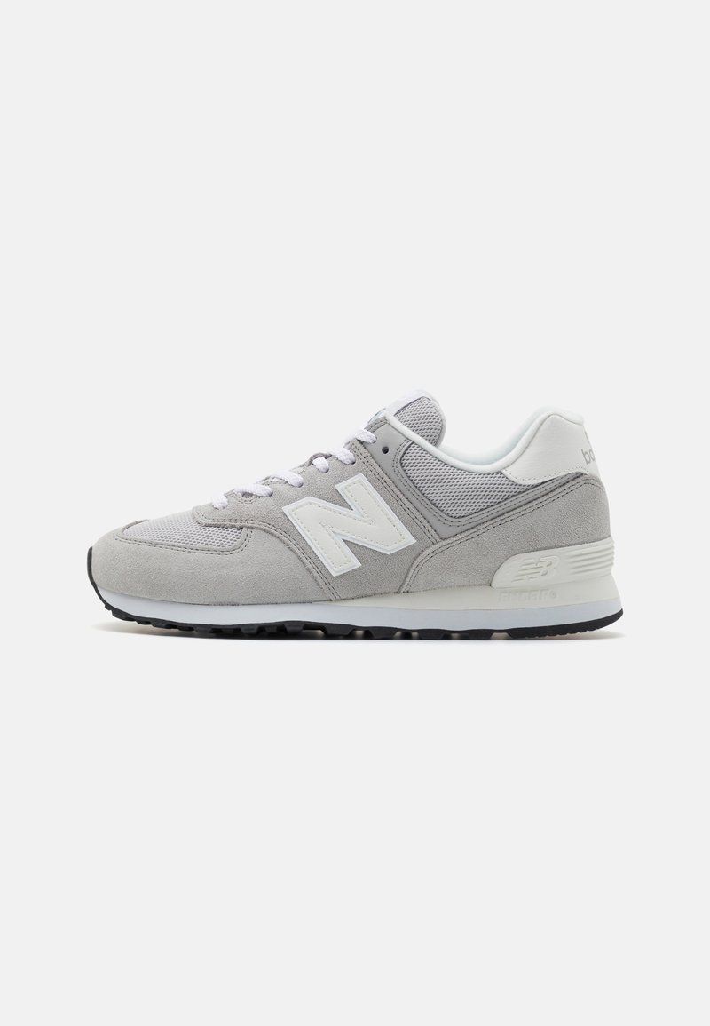 Baskets New Balance grises et blanches avec panneaux en daim et en mesh, design à lacets, et semelle en caoutchouc, vues de profil sur fond blanc.