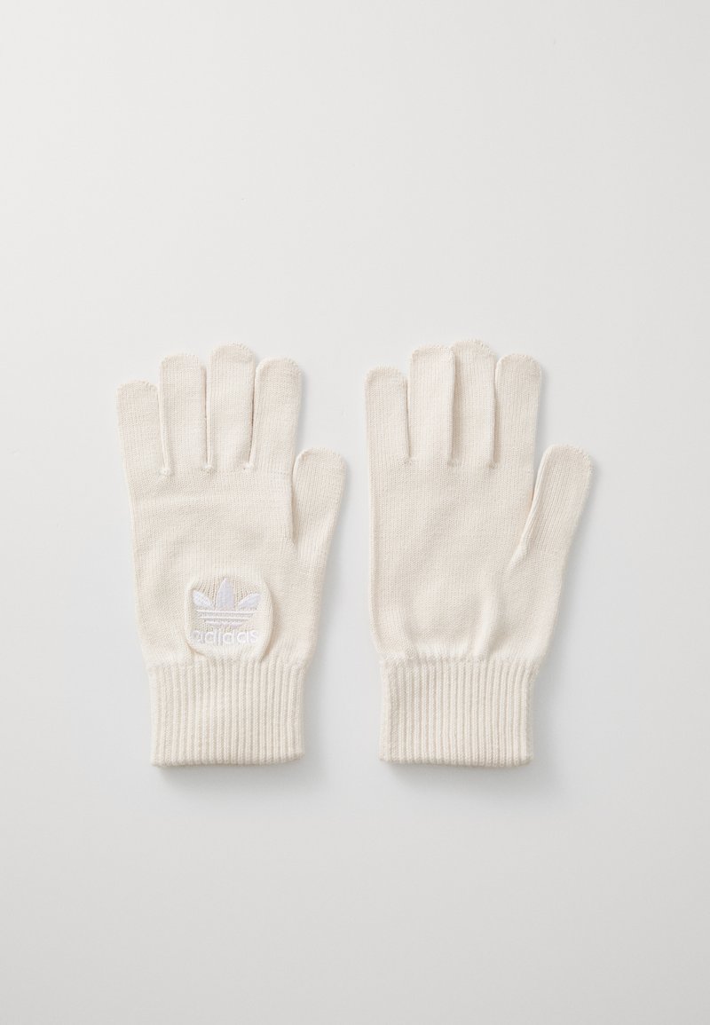 Fehér kötött kesztyű ribbelt mandzsettával, a csuklón egy kis hímzett logóval. Sima tapintású és öt ujjas dizájn.