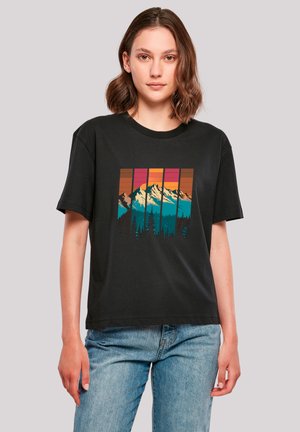Black cotton t-shirt featuring a colorful mountain landscape graphic with teal, orange, and pink tones, set against a forest silhouette.