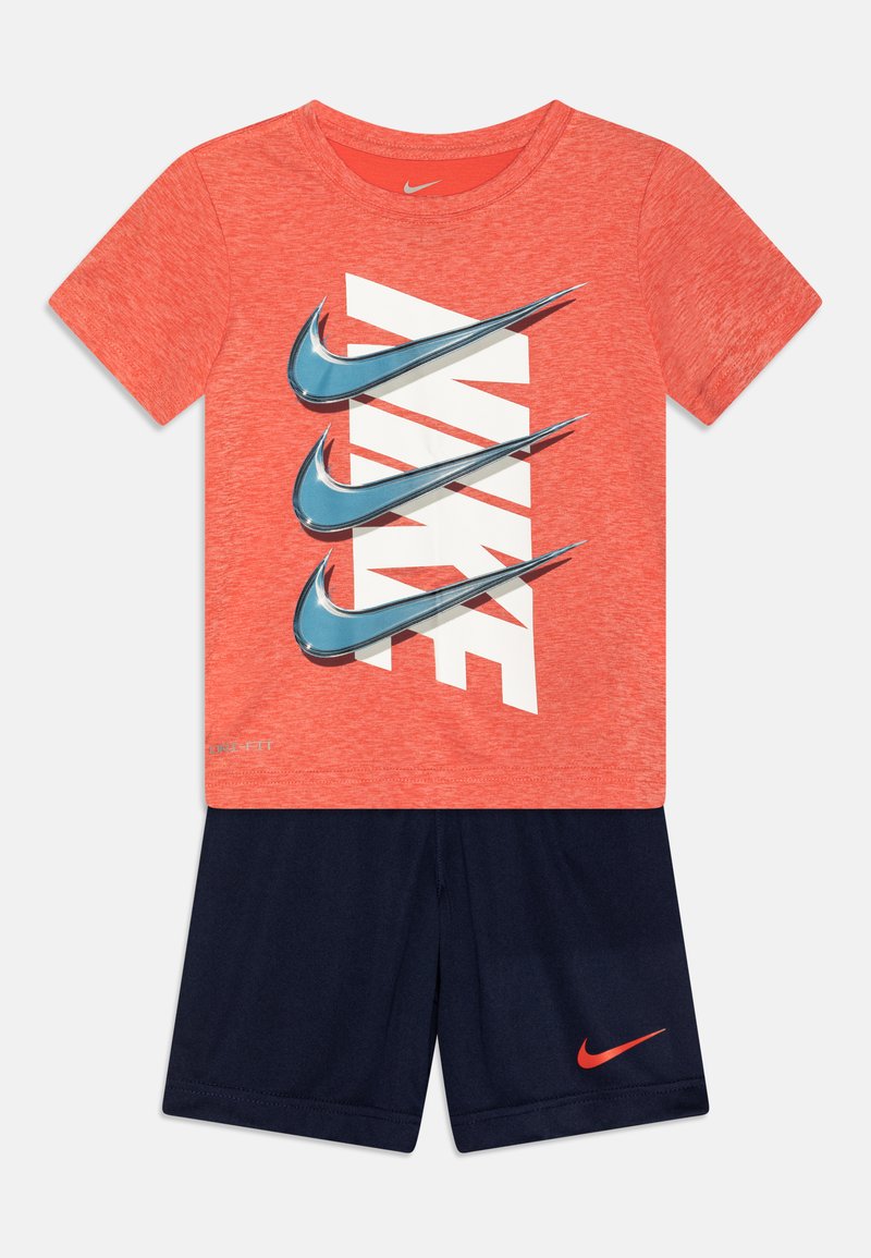 Κόκκινο μπλουζάκι T-shirt με λευκό λογότυπο Nike και μπλε swooshes, συνδυασμένο με ναυτικές βραχιόνες με μικρό κόκκινο λογότυπο Nike. Μαλακό ύφασμα, αθλητική εφαρμογή.