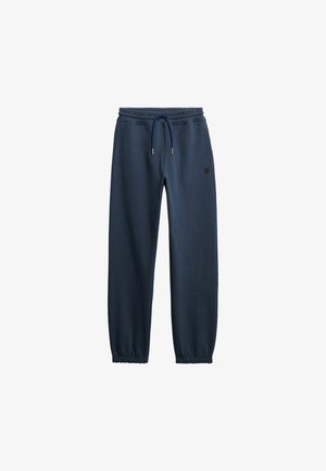 Marineblå joggingbukser med elastisk talje og manchetter, justerbar snøre og lille logo på venstre lår.