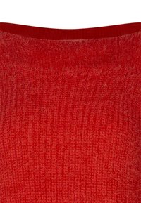 Tissu tricoté rouge présentant un motif doux et texturé avec un décolleté légèrement incurvé. La surface semble chaude et accueillante.