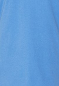 Světle modré tričko s krátkým rukávem z měkkého bavlněného materiálu. Nabízí jednoduchý, jednobarevný design bez grafiky nebo vzorů.