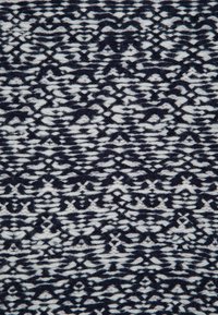 Tissu tricoté noir et blanc avec un motif géométrique abstrait composé de rangées horizontales présentant des croix et des diamants.