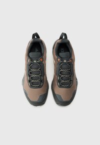 Braune und schwarze Sport Schuhe mit einer strukturierten Oberseite, Gummisohle, reflektierenden Akzenten und elastischen Schnürsenkeln. Doppelter Ziehverschluss für einfaches An- und Ausziehen.