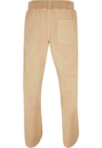 Beige sweatpants med elastisk talje og en enkelt baglomme. Glat tekstur, tætsiddende ben og ingen synlige mønstre eller detaljer.