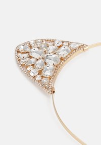 Hårtilbehør i gulltone med triangulært design, prydet med klare rhinestones i ulike former og størrelser, aksentuert med mindre edelstener.