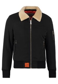 Svart bomberjacka med krämfärgad fuskpälskrage, dragkedjestängning, ribbade mudd och nederkant. Har två sidofickor och en orange etikett detalj.