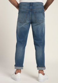 Jeans de mezclilla de un azul claro con un ajuste relajado, que cuentan con dobladillos enrollados, dos bolsillos traseros y un ligero desgaste en la tela.