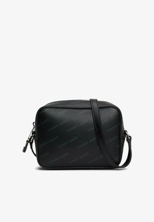Bolso cruzado sintético negro con el logotipo en relieve "TOMMY JEANS", forma rectangular, correa ajustable y herrajes de cremallera en tono plateado.