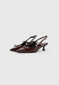 Burgundy patent leather slingback heels with pointed toes, slender ankle straps, and gold-tone circular accents. Low, slim heel.