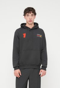 Γκρι βαμβακερό φούτερ με κουκούλα και τσέπη στο μπροστινό μέρος, κορδόνι στην κουκούλα, με κόκκινο αριθμό «1» και λογότυπο στο στήθος, με λεία υφή.