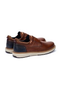 Scarpe in pelle marrone con accenti neri, suola beige e dettagli testurizzati. Presentano un design con lacci e un interno imbottito.