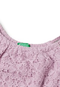 Top de encaje malva con escote fruncido y tirantes trenzados, que presenta una etiqueta verde con "United Colors of Benetton". Patrón floral detallado.