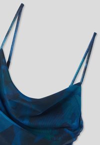 Niebieska siateczkowa tkanina z ciemnymi i jasnymi wzorami, tworząca drapowaną górę odzieży z cienkimi regulowanymi ramiączkami.