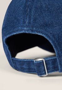 Cappello in denim di colore blu scuro, con corona strutturata, dettagli cuciti e una fibbia in metallo argentato per la regolazione della taglia sul retro.