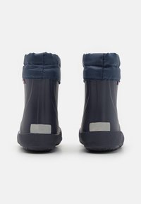 Botas de goma navy con un puño de tela suave, forma redondeada, suela texturizada y acentos reflectantes en la parte posterior para mayor visibilidad.