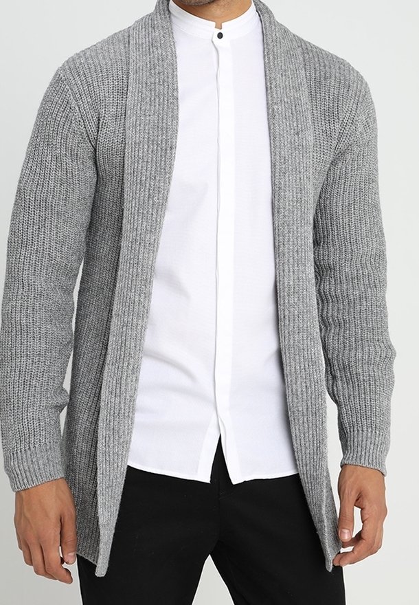 Cardigan grigio in maglia con design aperto, texture a costine e maniche lunghe, abbinato a una camicia bianca con colletto e pantaloni neri.