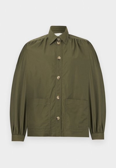 Πουκάμισο σε ελιά πράσινο, με κουμπιά, μακριά φουσκωτά μανίκια, δύο μπροστινές τσέπες και μυτερό γιακά.