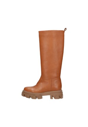 Botte haute en cuir marron avec semelle épaisse à rainures et languette à l'arrière, vue de profil sur fond blanc.