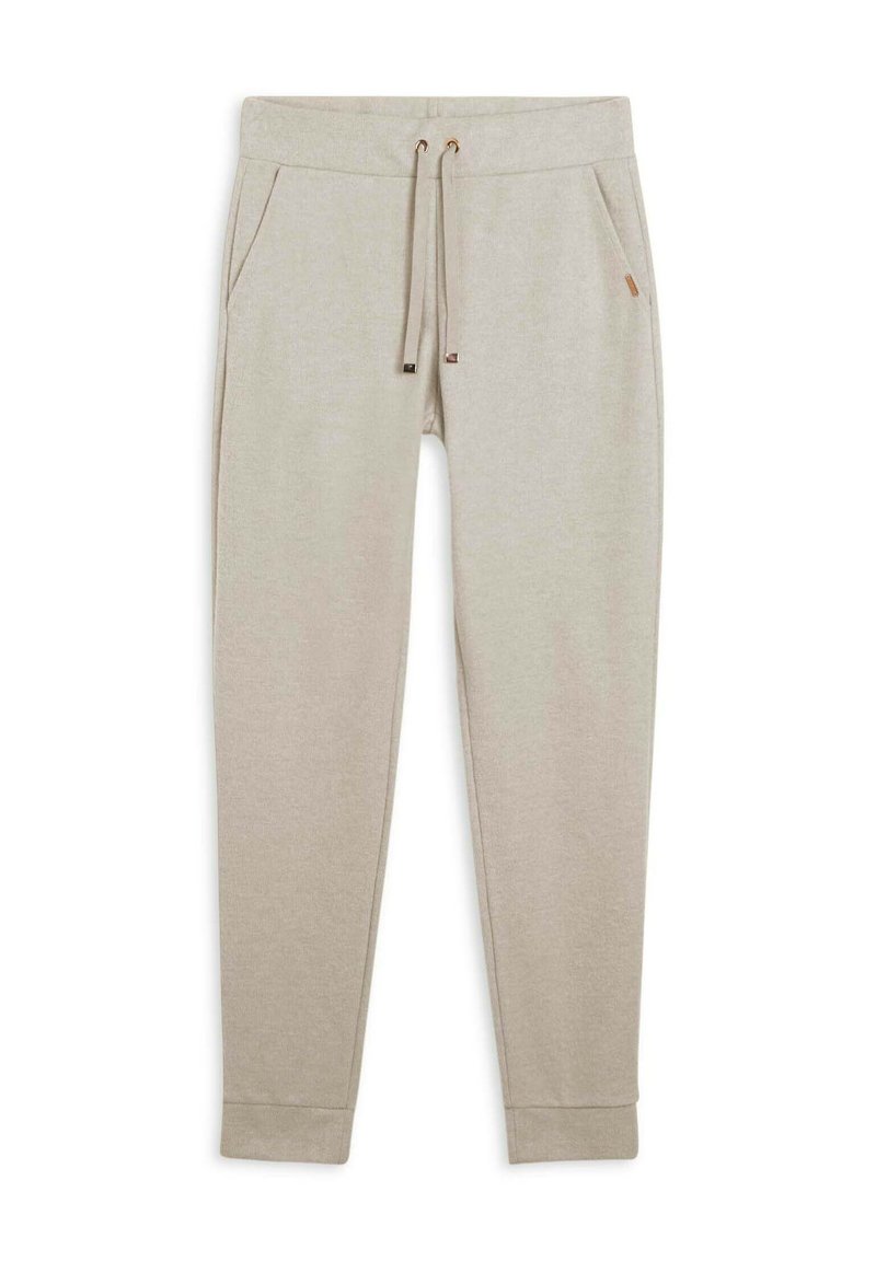 Pantalones jogger en beige claro hechos de tela suave, con cintura ajustable con cordón, dos bolsillos laterales y puños acanalados. Sutil detalle de logo en la cintura.