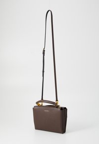 Brown leather handbag with a structured design, gold-tone hardware, a top handle, and an adjustable strap. Textured surface with a zip closure.