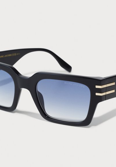 Gafas de sol negras en forma rectangular con lentes degradados azules. Presentan rayas doradas en las patillas. El material parece brillante y texturizado.