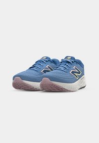 Scarpe da ginnastica blu con tomaia in rete, caratterizzate da un logo in tonalità pastello e una suola bianca testurizzata con dettagli rosa e neri.