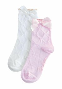 Balta un rozā ankl sāku pāris. Baltajā zeķē ir loks un tekstūrēts dimanta raksts; rozā zeķei ir atbilstošs loks un līdzīgs dizains.